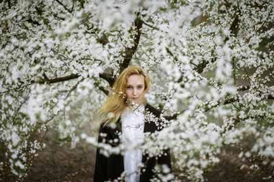 A photo of a beautiful Ukrainian woman standing in front of a tree